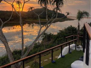 a view of a lake from a balcony with palm trees at Blues at Bonza Bay Beach in Beacon Bay