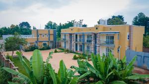 a large yellow building with a yard at E-Residences in Gulu