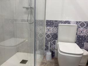 a bathroom with a toilet and a glass shower at La Casa del Encinar in Valdemorillo