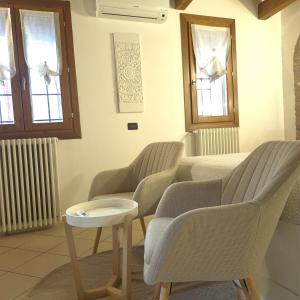 a waiting room with chairs and a table and windows at Nell'antico ghetto ebraico in Ferrara +33 photos