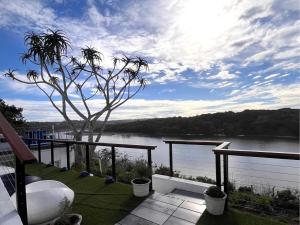 a balcony with a view of a river and a tree at Blues at Bonza Bay Beach in Beacon Bay +5 photos