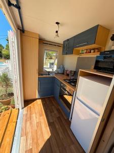 a kitchen with blue cabinets and a white refrigerator at La Finquilla Holidays in Estepona