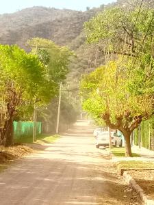 a road with cars parked on the side of a mountain at Cabañita La Paz Villa Sanagasta in Villa Bustos