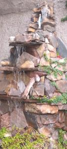 a rock fountain with a bird sitting on top of it at Cabañita La Paz Villa Sanagasta in Villa Bustos
