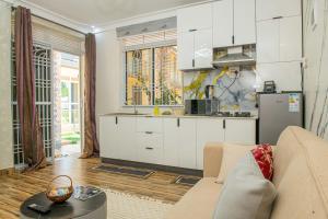 a living room with a couch and a kitchen at E- Residence in Gulu