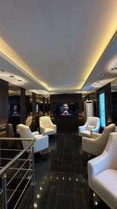 ein Wartezimmer mit weißen Stühlen und einem Flachbildfernseher in der Unterkunft ADMİRAL in Kayseri + 15 Fotos