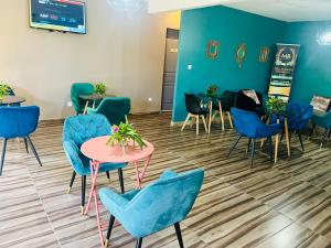 a waiting room with blue chairs and tables at Moya Résidence by MD in Dzaoudzi
