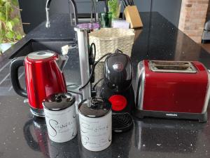three coffee cups sitting on a counter next to a toaster at Golf Style in Lisdoonvarna +19 photos