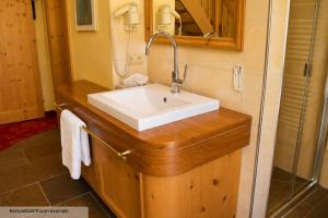 a bathroom with a white sink and a shower at Sporthotel Auhof in Kappl +129 photos