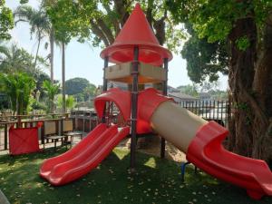 a red slide in a park with a tree at Lakeview Cabanas - Unit 11 in St Lucia