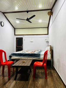 a room with a bed and two red chairs at Lake breeze homestay in Shendi