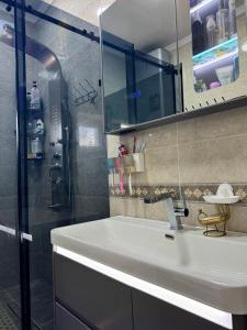 a bathroom with a white sink and a shower at Sabi Guest House in Bokonbayevo +39 photos