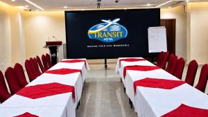 a room with red chairs and a screen with a presentation at Transit Hotel in Juba