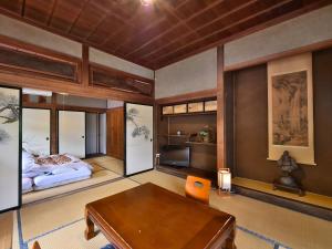 a bedroom with a bed and a table and a desk at Masuya Ryokan in Aoki +101 photos