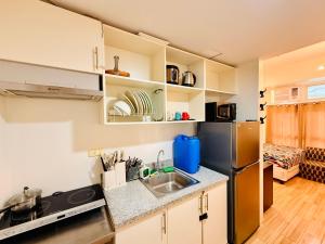 a kitchen with a sink and a refrigerator at JFam Suites, C3-9D Studio, Up To 4 Pax in Biñan
