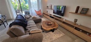 a living room with a couch and a tv at Holiday - Comfort - Spacious - Escape in Grand-Baie