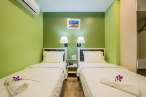 - 2 lits dans une chambre aux murs verts dans l'établissement inHotel Inanam, à Kota Kinabalu