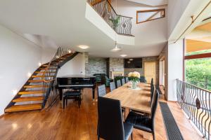 a dining room with a table and a piano at Vila Fénix in Kutná Hora