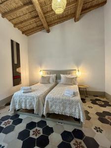 a bedroom with two beds and a table and a ceiling at Palazzo Ma.Ri.Lu. in Càbras