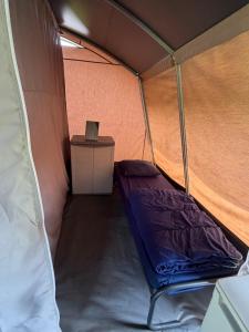 a small tent with a purple bed in it at Glamping in Style in Dronrijp