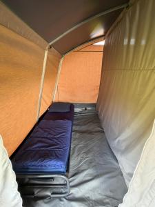 a small bed in a tent with the door open at Glamping in Style in Dronrijp