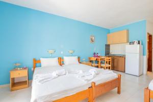 ein Schlafzimmer mit einem großen Bett und einer blauen Wand in der Unterkunft Studios Nina in Amoopi