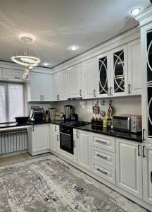 a white kitchen with white cabinets and appliances at Sabi Guest House in Bokonbayevo