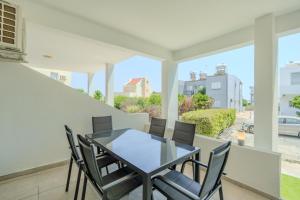 a dining room with a glass table and chairs at Sandy Beach Complex in Perivolia