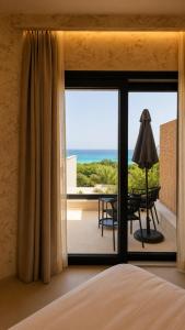 a bedroom with a large window with a view of the ocean at Naim Boutique Hotel in Costa Rei