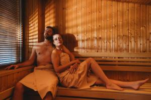 a man and a woman sitting in a sauna at Chalets Jasná Collection Záhradky in Belá +24 photos