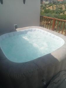 a large hot tub in a patio with a balcony at A casa do Avô Cruzes in Cerejais