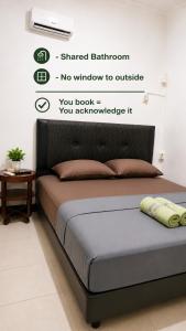 ein Bett in einem Schlafzimmer mit einem Schild an der Wand in der Unterkunft Moshi Moshi in Probolinggo