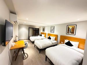 a hotel room with two beds and a desk at The Avenue Hotel in Islamabad +59 photos