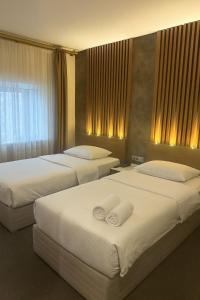 zwei Betten in einem Hotelzimmer mit weißer Bettwäsche in der Unterkunft ADMİRAL in Kayseri