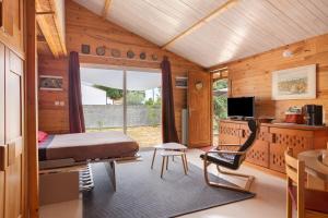 a bedroom with a bed and a desk and a television at Chalet Studio Athome in Bouhet