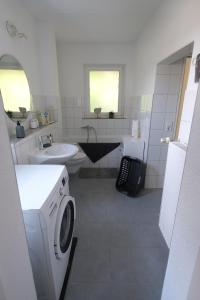 a bathroom with a washing machine and a sink at Haus im Ländle in Volkertshausen
