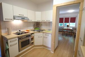 a kitchen with white cabinets and a stove top oven at Haus im Ländle in Volkertshausen