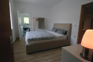 a bedroom with a bed and a table with a lamp at Haus im Ländle in Volkertshausen