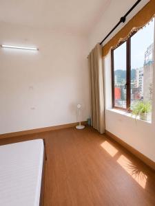 an empty room with a large window and a bed at Nhà nghỉ Hoa Ngàn Tam Đảo in Tam Ðảo +8 photos
