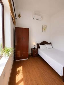 a bedroom with a large white bed and a window at Nhà nghỉ Hoa Ngàn Tam Đảo in Tam Ðảo