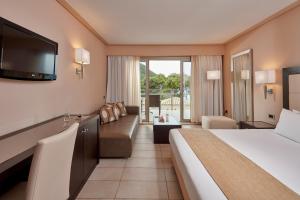 a hotel room with a bed and a television at Atlantica Grand Mediterraneo Resort - Adults Only in Kompítsion +81 photos