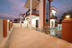 ein Haus mit einem Gehweg vor dem Gebäude in der Unterkunft II EMPYREAN STAYS II SU CASA VILLA II 4BHK II AC II PRIVATE POOL Il in Lonavla