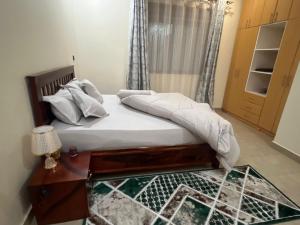 a bedroom with a bed with a table and a window at Princess selection suites in Wakiso