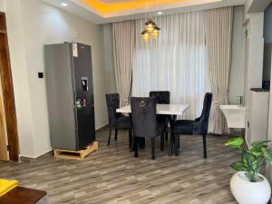 a dining room with a white table and black chairs at Princess selection suites in Wakiso