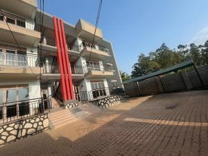 a building with red columns in front of it at Princess selection suites in Wakiso