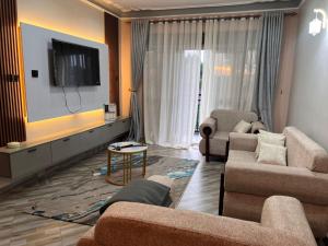 a living room with two couches and a flat screen tv at Princess selection suites in Wakiso