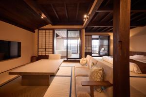 a living room with a couch and a bed at いっぺ The Sake Ryokan in Kyonan
