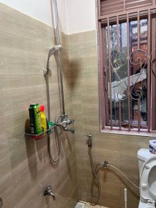 a shower in a bathroom with a toilet and a window at Princess selection suites in Wakiso +11 photos