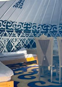 a bedroom with a bed with a canopy and a table at Sabi Guest House in Bokonbayevo