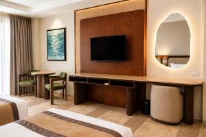 a hotel room with a bed and a television at Coron Westown Resort in Coron
